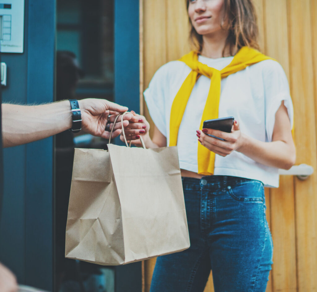 A delivery man delivering the parcel to a woman.