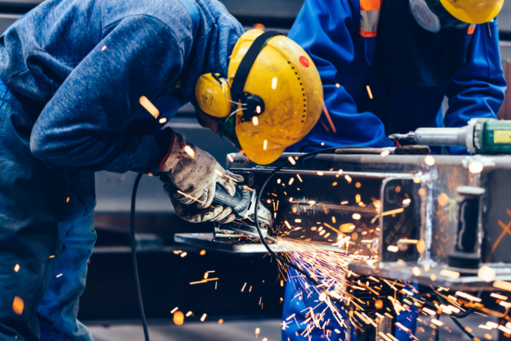 A close-up shot of a worker with a metal grinder in his hand.