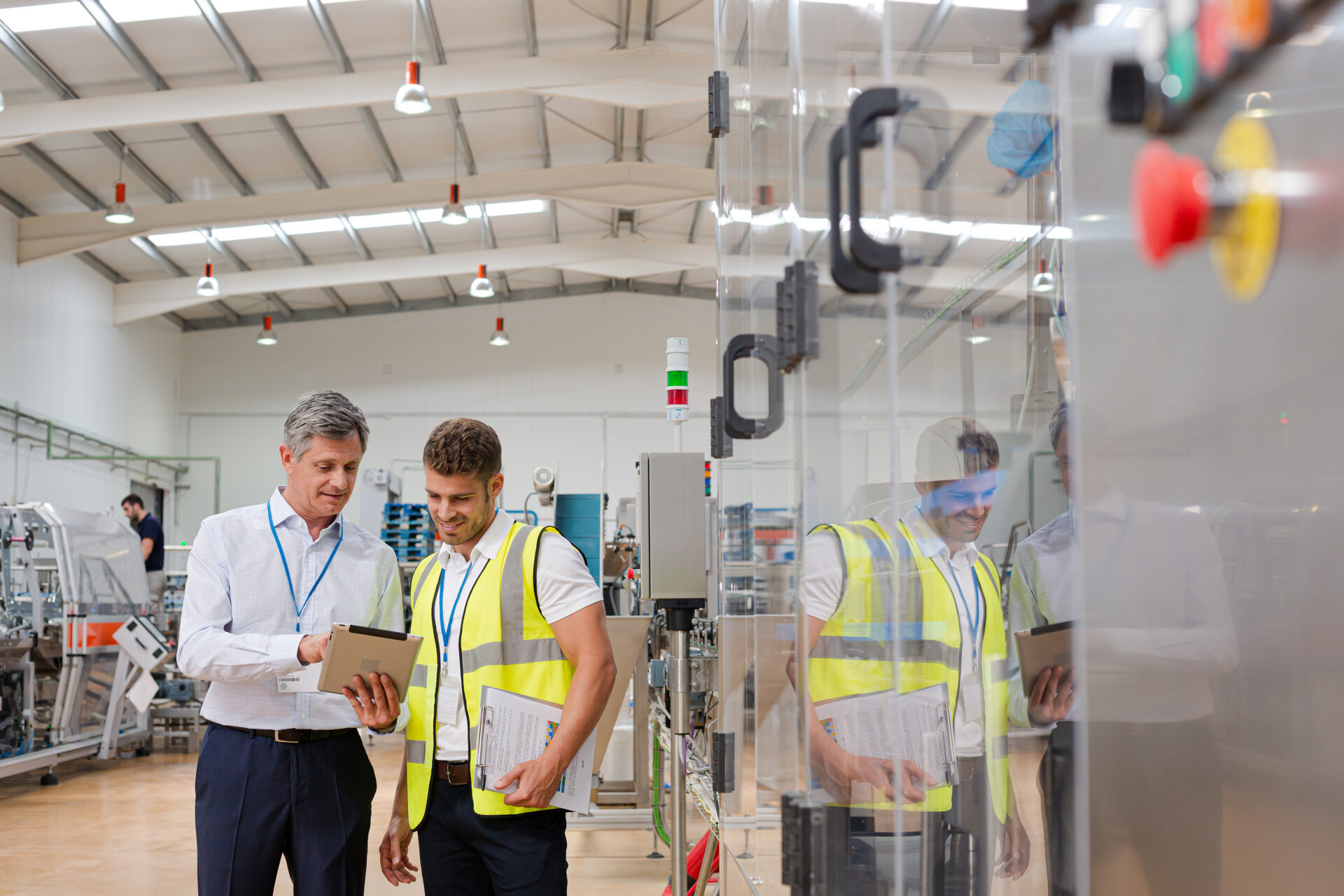 Two engineers discussing about work at a manufacturing plant.