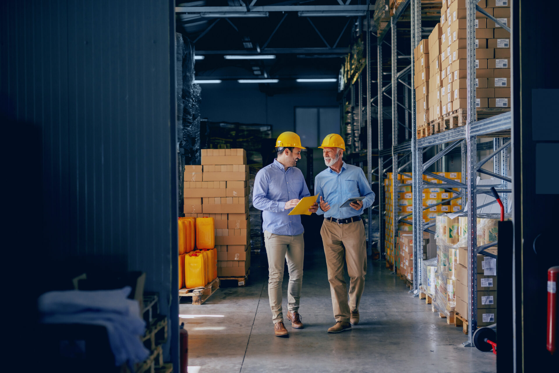 A manager and an employee standing in a warehouse.