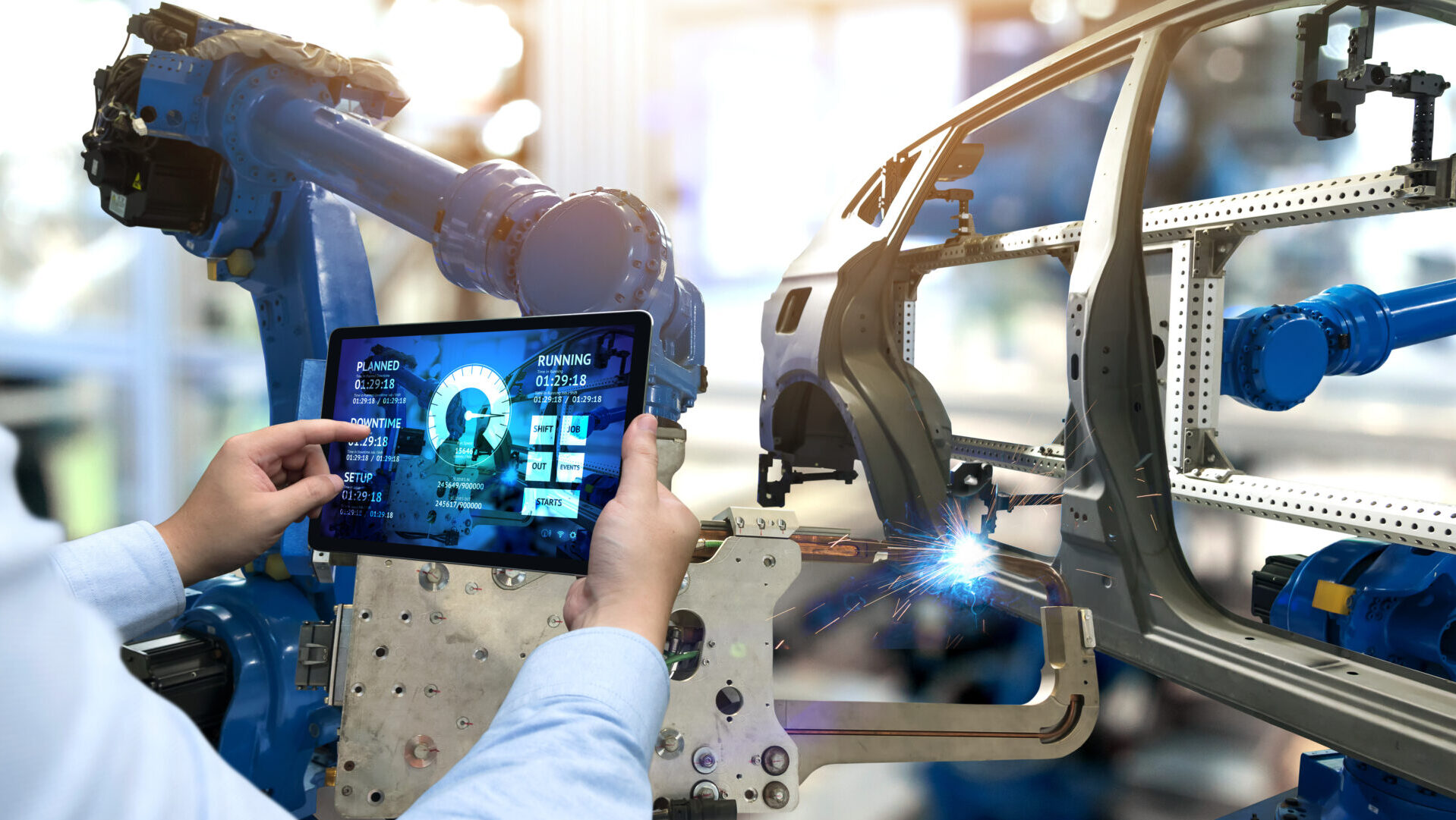 An engineer using a tablet to control the operations on production line.