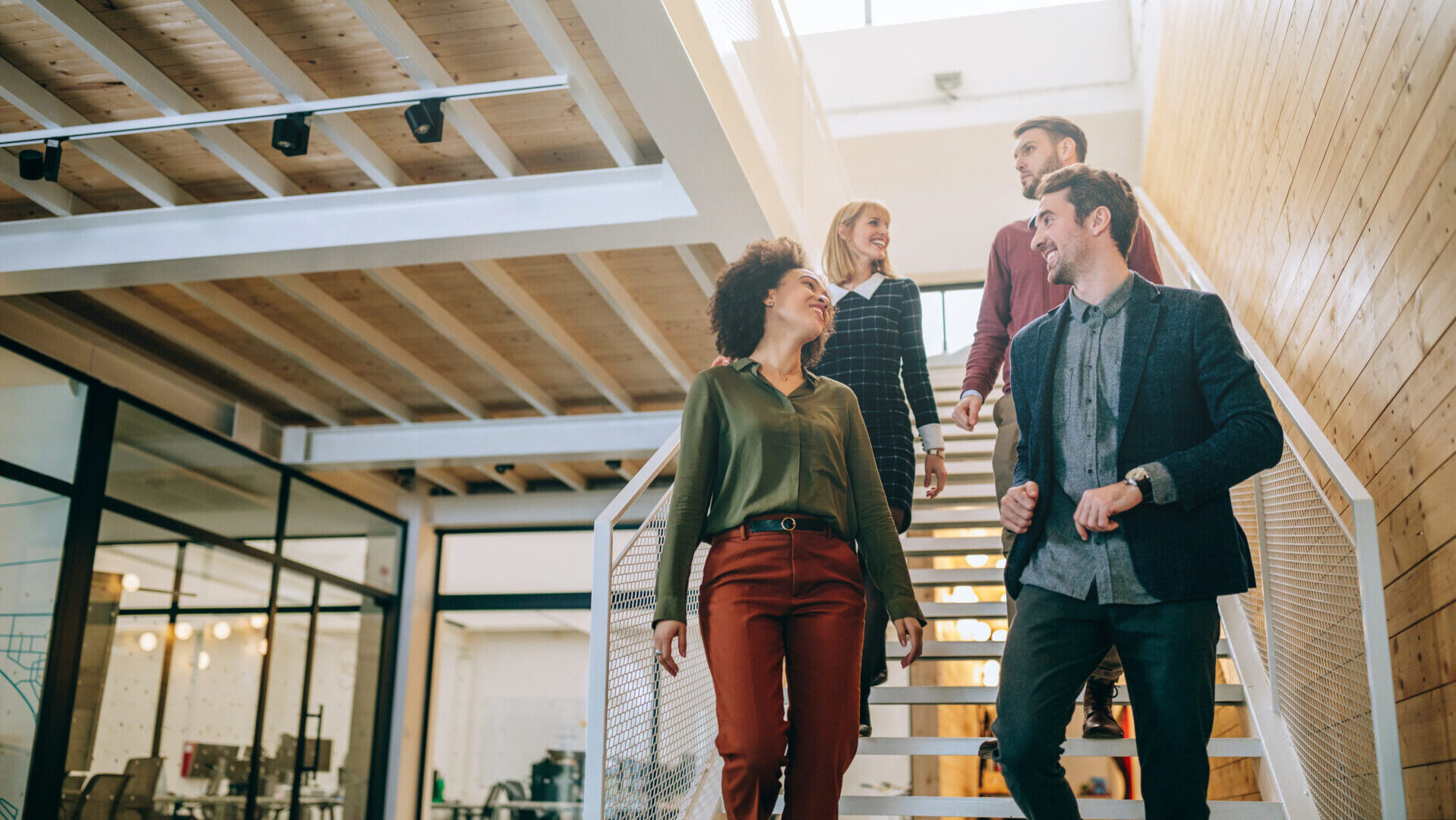 A group of coworkers walking down the stairs in an office.